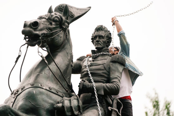 بالصور.. الشرطة الأمريكية تمنع متظاهرين من إزالة تمثال رئيس سابق هجّر الهنود الأصليين