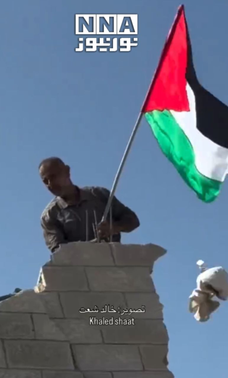 דגל פלסטין מתנוסס מעל הריסות עזה.